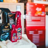 A collection of car care products displayed in a vibrant garage environment.